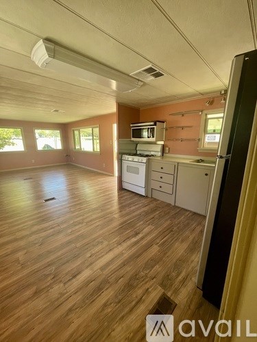 A kitchen with wooden floors and a white stove top oven.