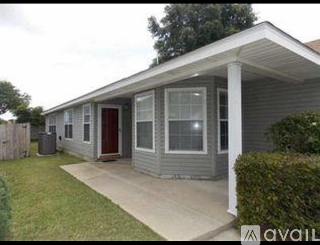 A small house with a red door and a porch.