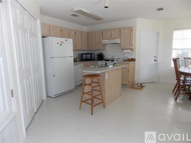 A kitchen with white appliances and wooden cabinets.