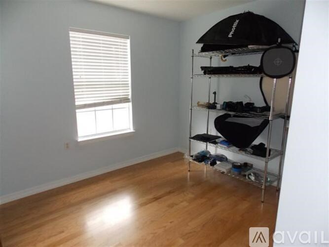 A room with a shoe rack and a window.