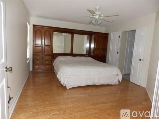 A bedroom with a bed, dresser, and mirror.
