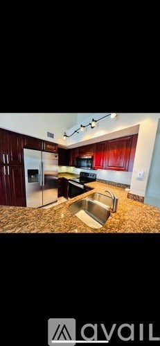 A kitchen with wooden cabinets and a stainless steel sink.