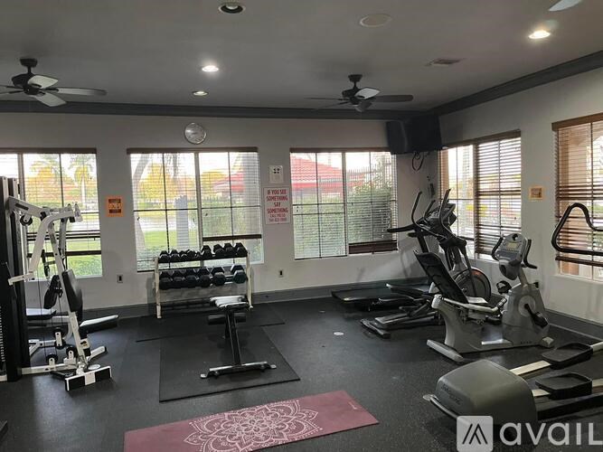A gym with a variety of equipment including treadmills, weights, and exercise machines.