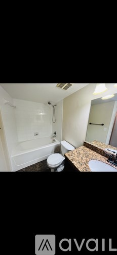 A bathroom with a toilet, sink, and shower.