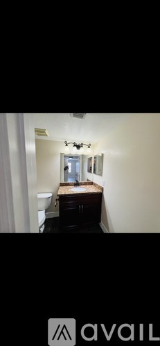 A bathroom with a sink, mirror, and toilet.