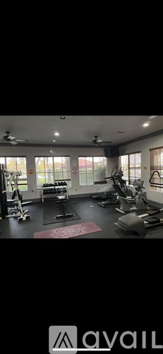 A gym with various exercise equipment and a red mat on the floor.