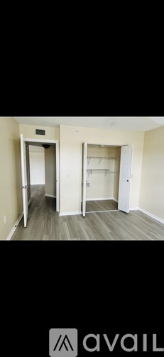 Two open doors in a room with wooden floors.