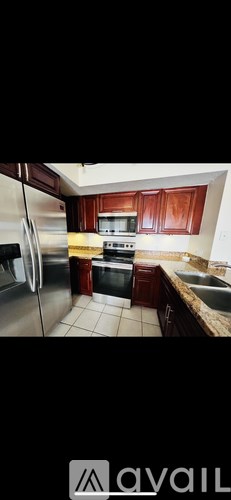 A kitchen with wooden cabinets and a stainless steel refrigerator.