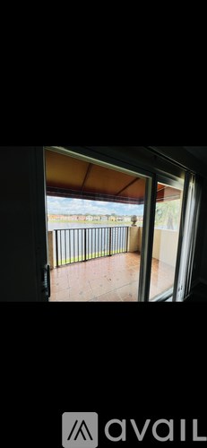A balcony with a metal railing and a view of a field.