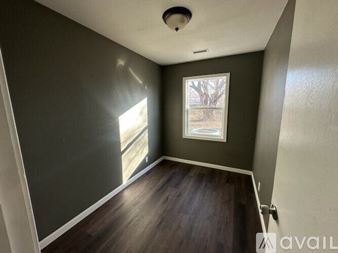 A room with a window and wooden flooring.