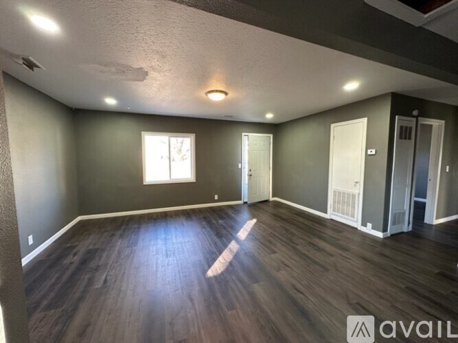 A room with wooden floors and a window letting in natural light.