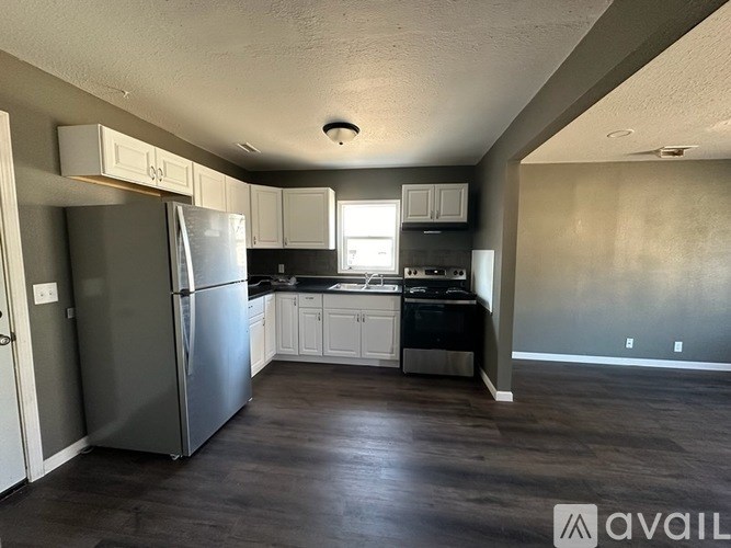 A kitchen with a refrigerator, cabinets, and a dishwasher.