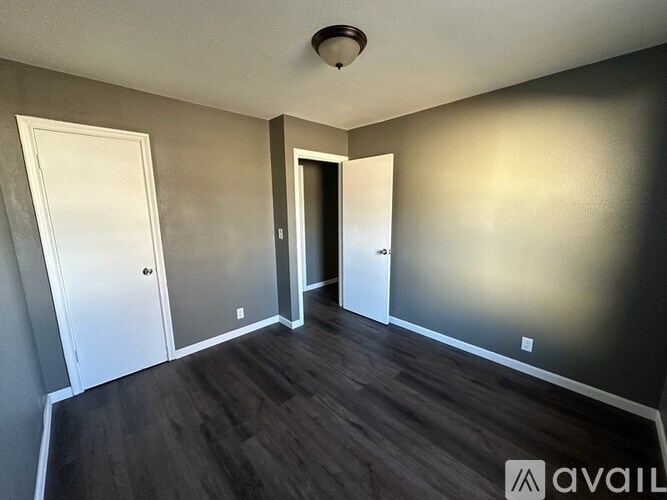 A room with a white door on the left and a black door on the right.