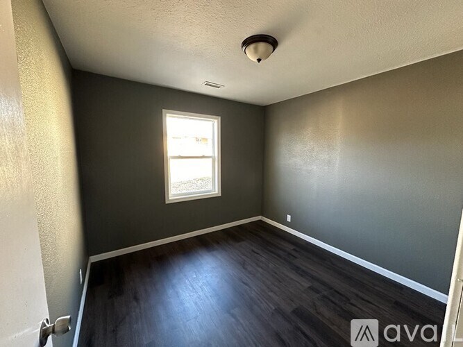 A room with a window and wooden floors.