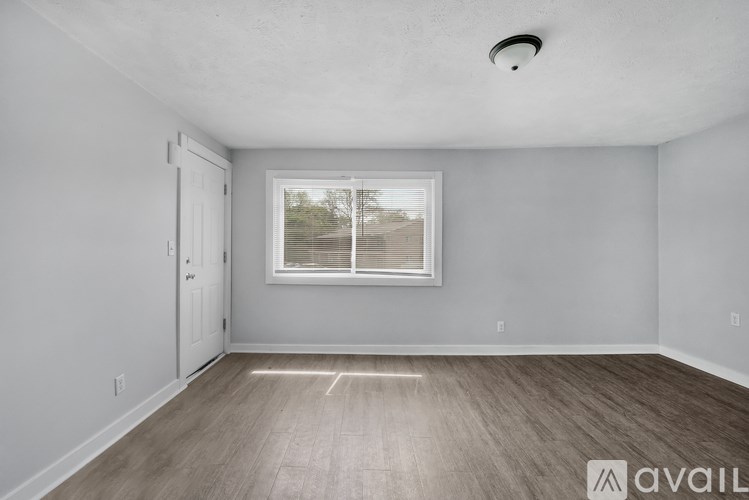 A room with a window and wooden flooring is available for rent.