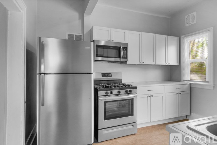 A modern kitchen with a stainless steel refrigerator, microwave, oven, and cabinets.