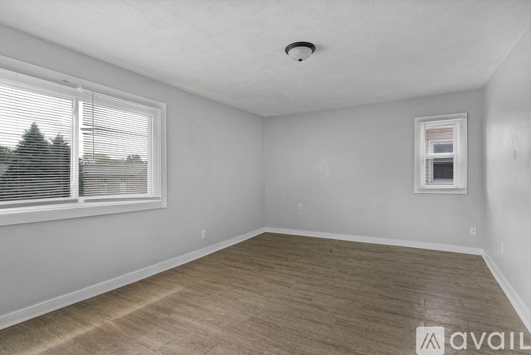 A room with a window and wooden flooring is available for rent.