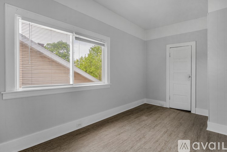 A room with a window and a door is available for rent.