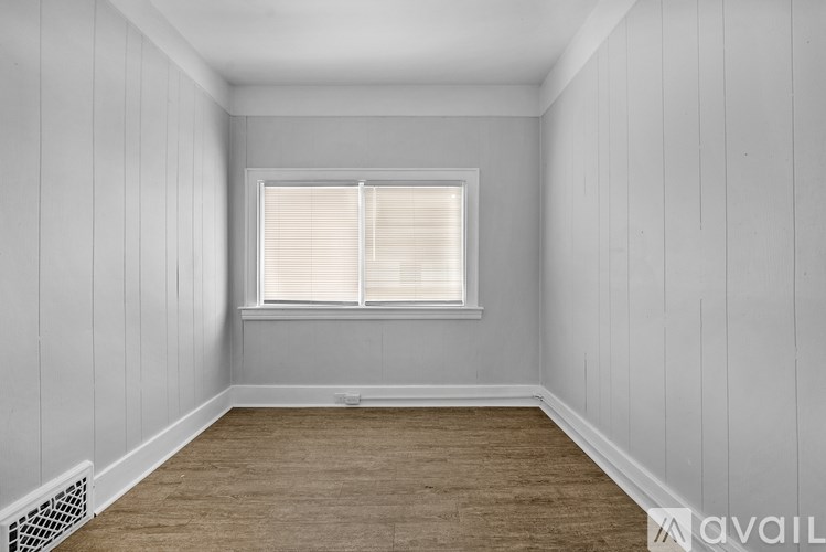 A room with a window and wooden flooring.
