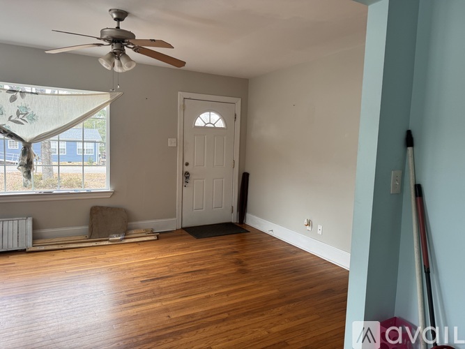 A room with a white door and a ceiling fan.