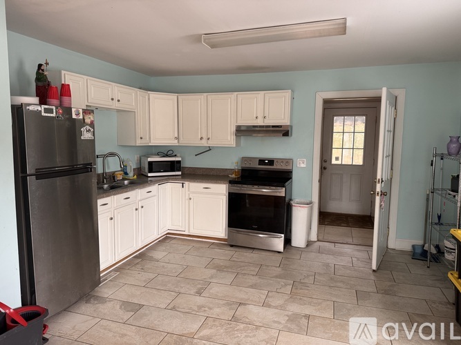 A kitchen with a refrigerator, microwave, oven, and cabinets.