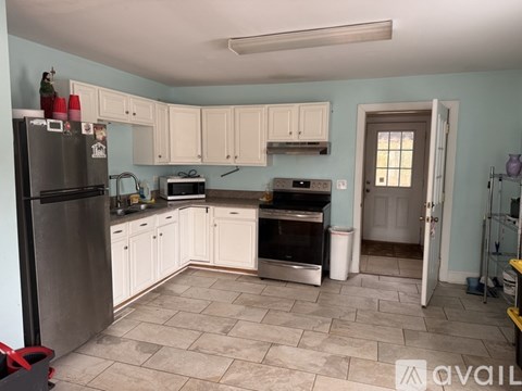 A kitchen with a refrigerator, microwave, oven, and cabinets.