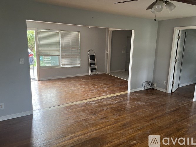 A room with wooden floors and a ceiling fan.