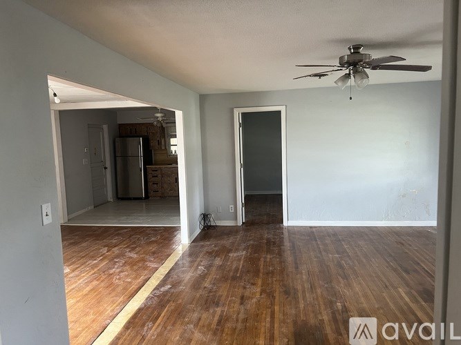 A room with wooden floors and a ceiling fan.