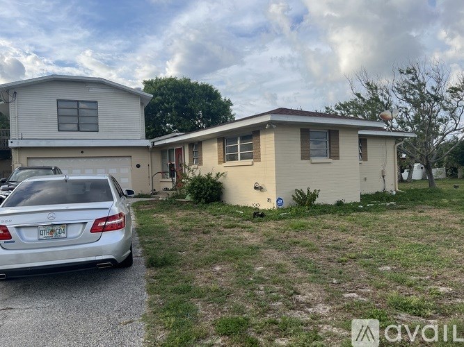 A silver car is parked in front of a house with a license plate that reads "GT1124".