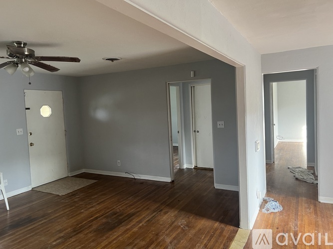 A room with a ceiling fan and wooden floors.
