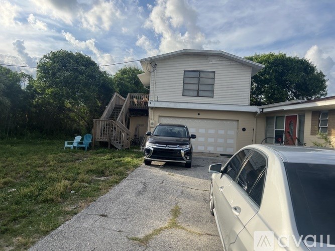 A white house with a car parked in front of it.