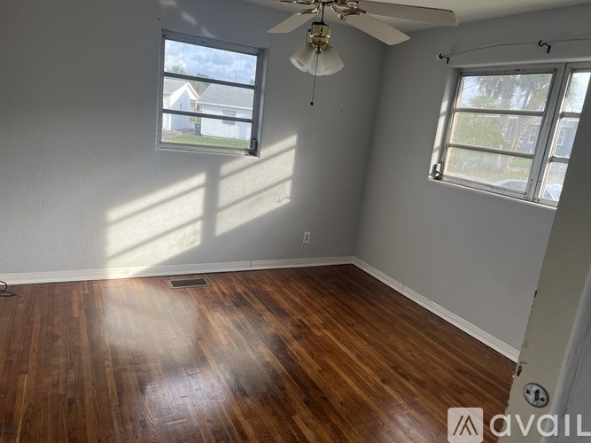 A room with wooden floors and a ceiling fan.