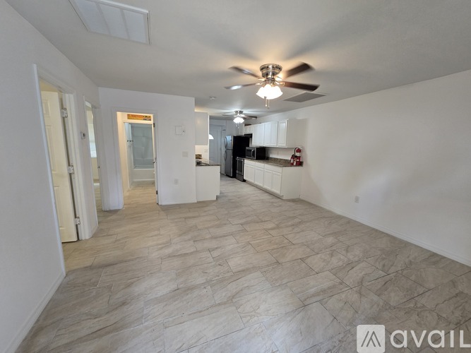 A spacious room with a ceiling fan and tiled flooring.