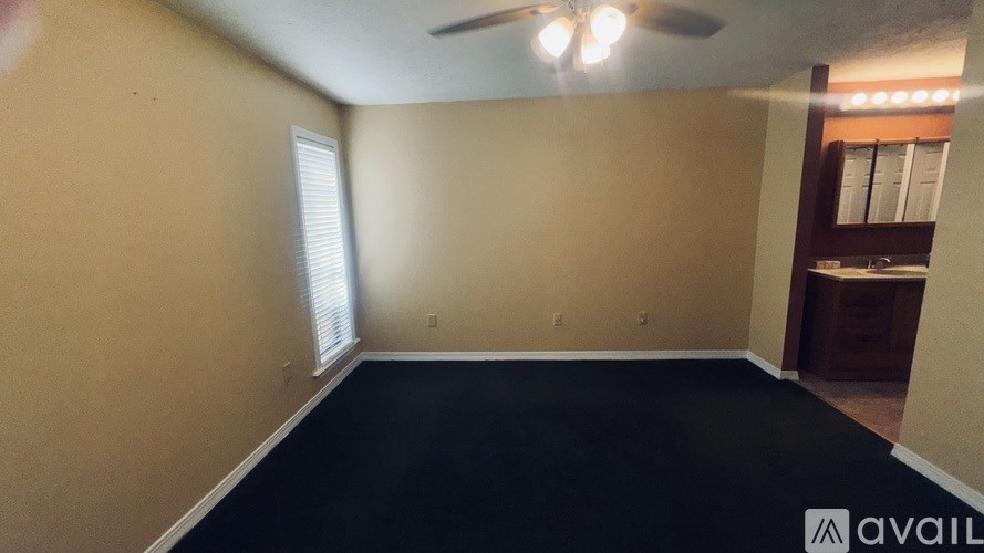 A room with a black floor and a ceiling fan.