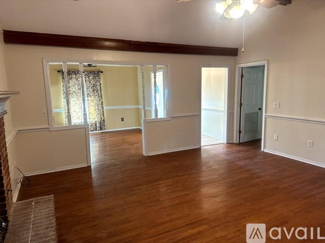 A room with wooden floors and a ceiling fan.