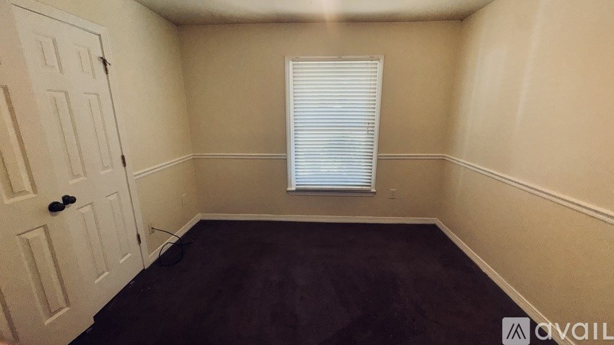 A room with a white door and a window with blinds.