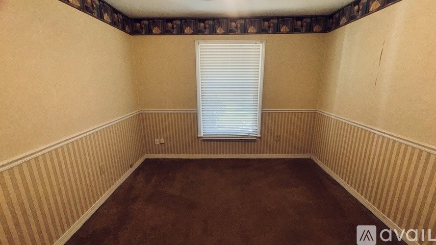 A room with a striped wallpaper and a window with blinds.