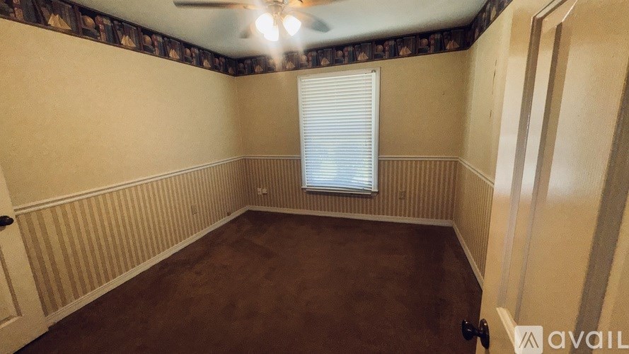 A room with a ceiling fan and a window with blinds.