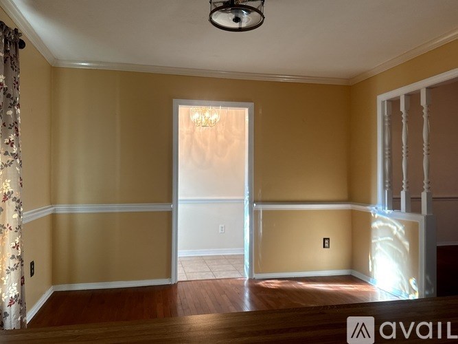 A room with a chandelier and a window with light coming through.