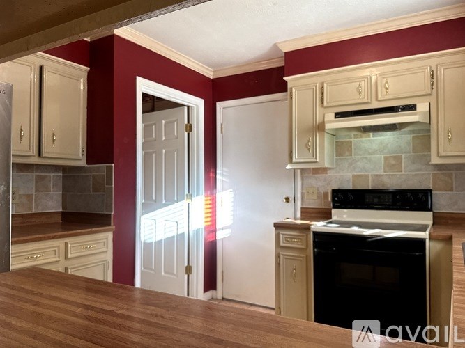 A kitchen with a black oven and wooden floors.
