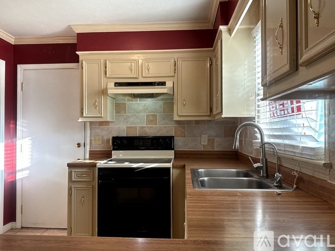 A kitchen with a black oven and a white fridge.