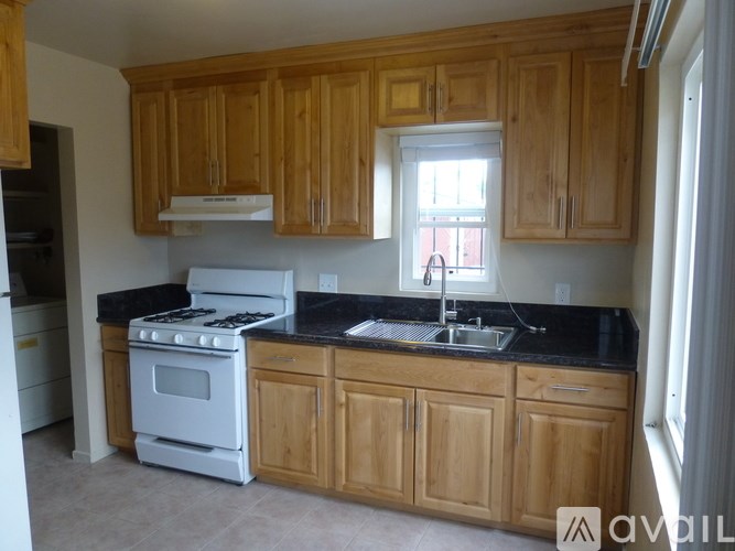 A kitchen with wooden cabinets and a black countertop.