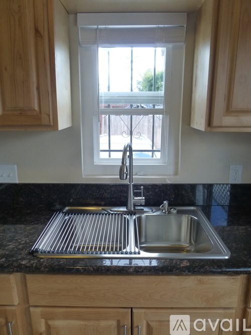 A kitchen with wooden cabinets and a black granite countertop.