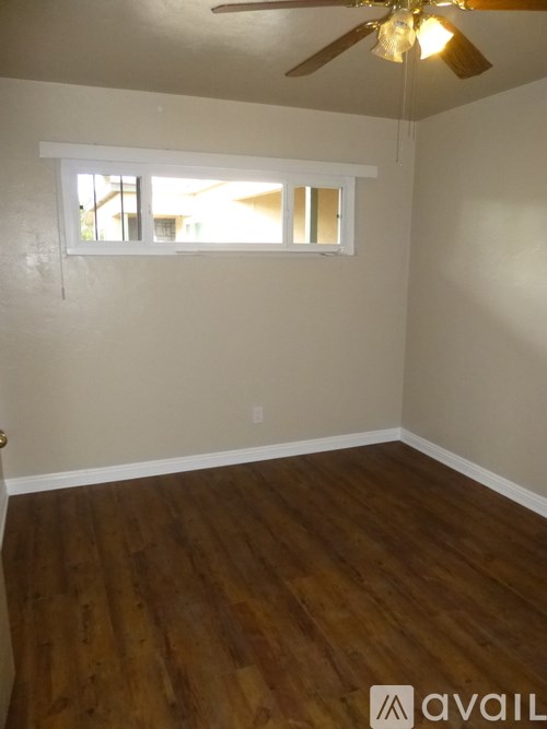 A room with a ceiling fan and a window.