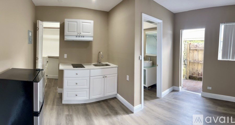A kitchen with a black countertop and white cabinets.
