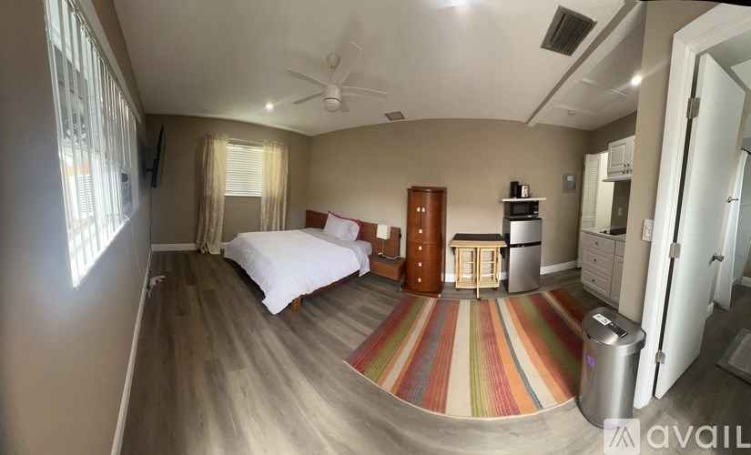 A bedroom with a bed, dresser, and a ceiling fan.