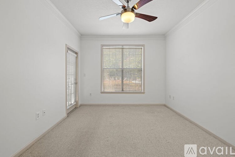 A room with a ceiling fan and a window with blinds.