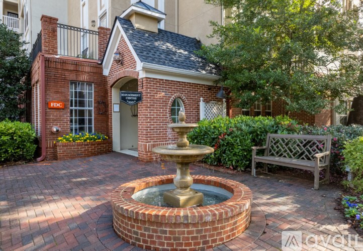 A brick house with a fountain in front.