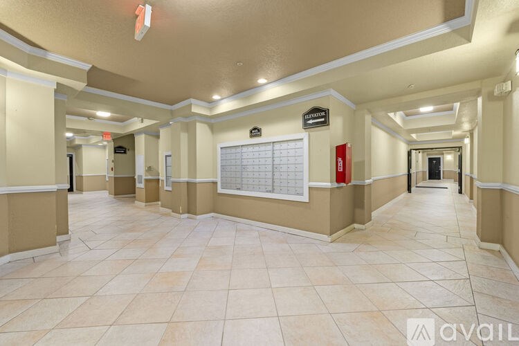 A long hallway with a calendar on the wall and a red fire extinguisher.