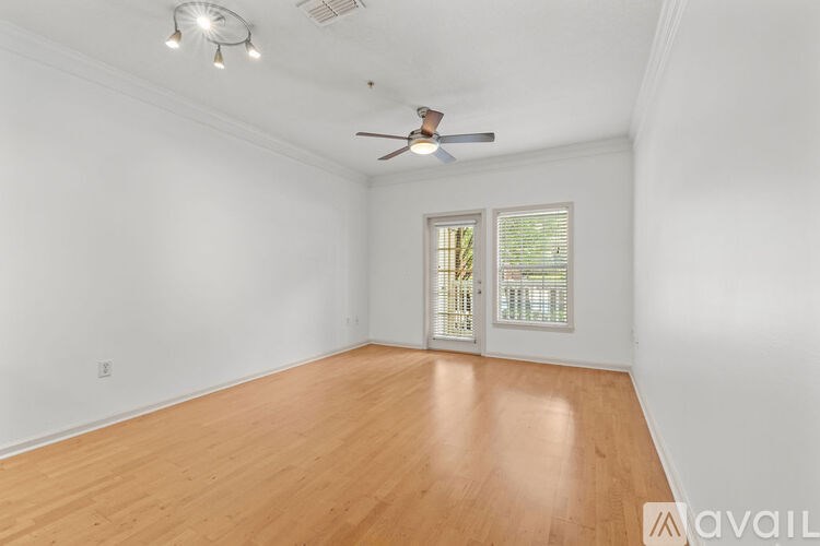 A room with a ceiling fan and wooden flooring.
